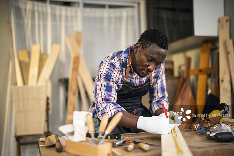 用卷尺在木板上标记尺寸的承包商图片素材