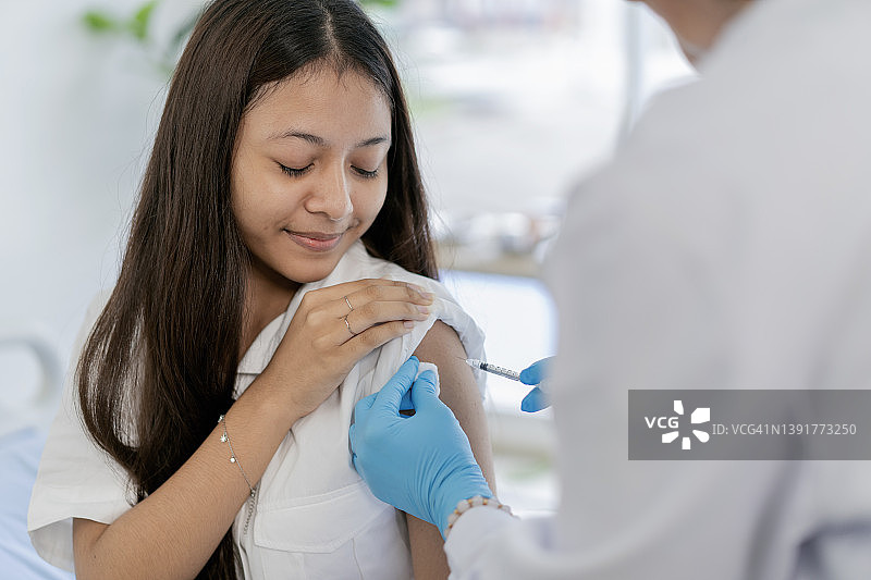 少女从护士那里接种新冠疫苗图片素材
