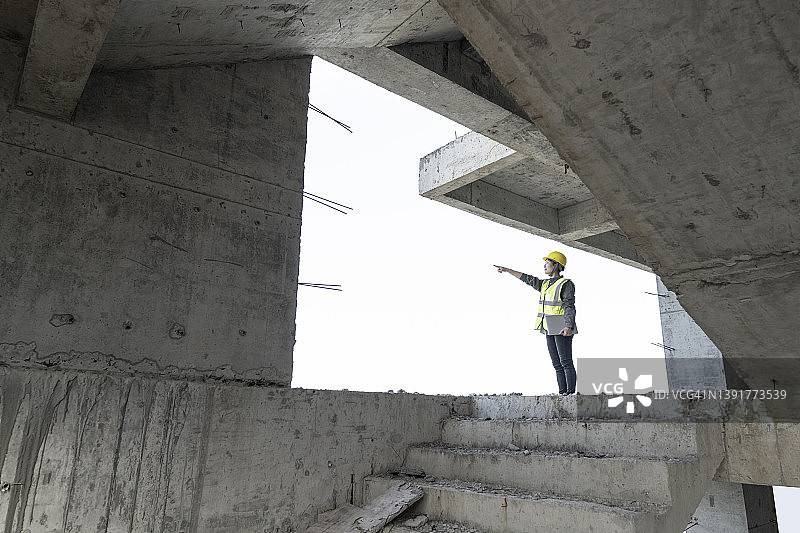 一位亚洲女工程师在未完工的建筑中工作图片素材