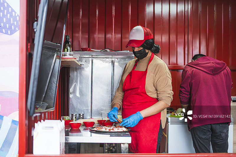 小型披萨店的员工为顾客准备食物图片素材