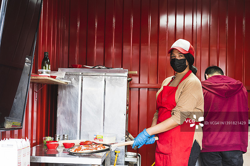 小型披萨店的员工为顾客准备食物图片素材