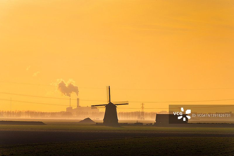 夕阳下的荷兰传统风车和工厂剪影图片素材