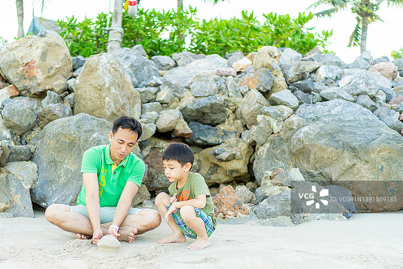 父子在沙滩上玩沙子图片素材