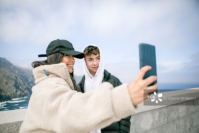 朋友们在西班牙加利西亚的奥特加尔角灯塔自拍图片素材
