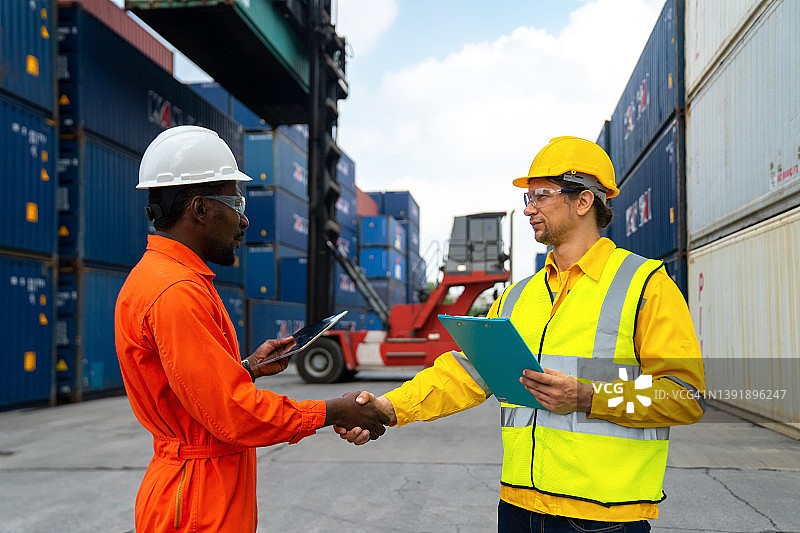 在港口控制从货船装载集装箱。工头控制工业集装箱货船。运输和物流概念图片素材