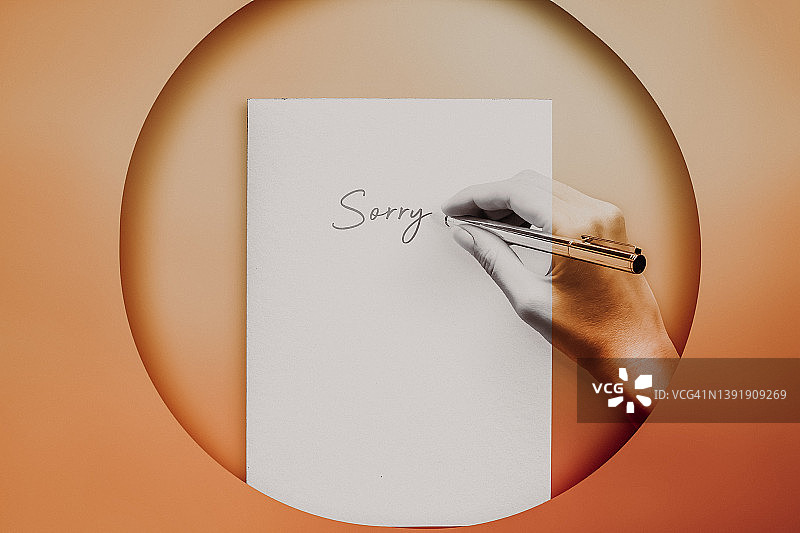 我很抱歉留言。女性的手在纸上书写的概念图图片素材