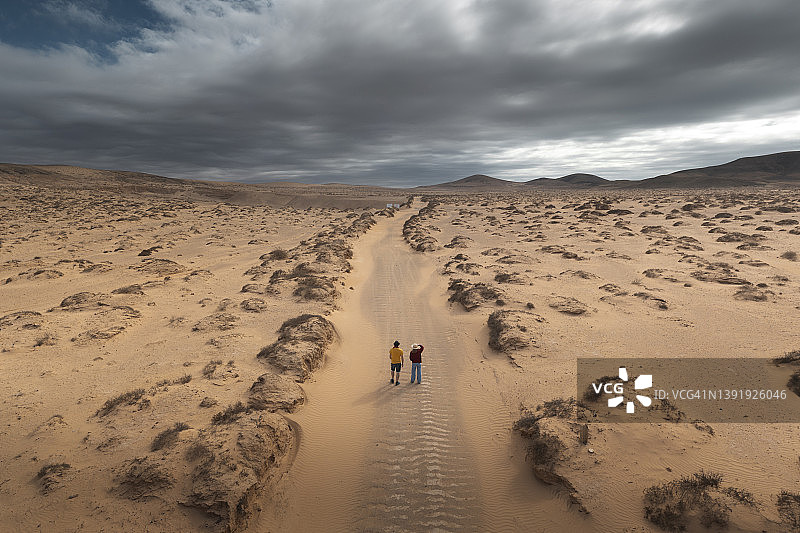 沙漠公路上的两人（航拍视角）图片素材