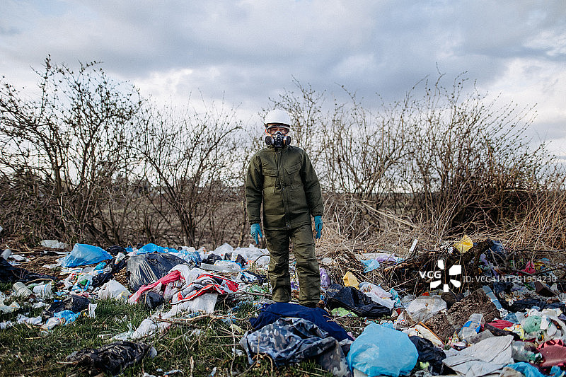 穿着防护服的女人站在垃圾中图片素材