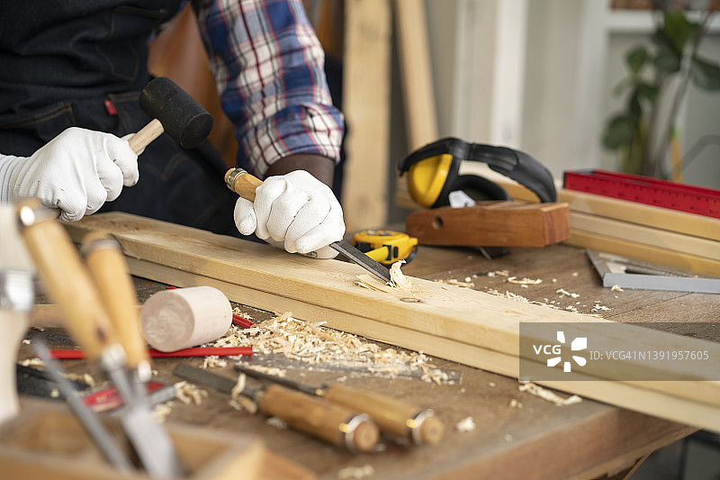 经验丰富的木匠用凿子雕刻木头图片素材