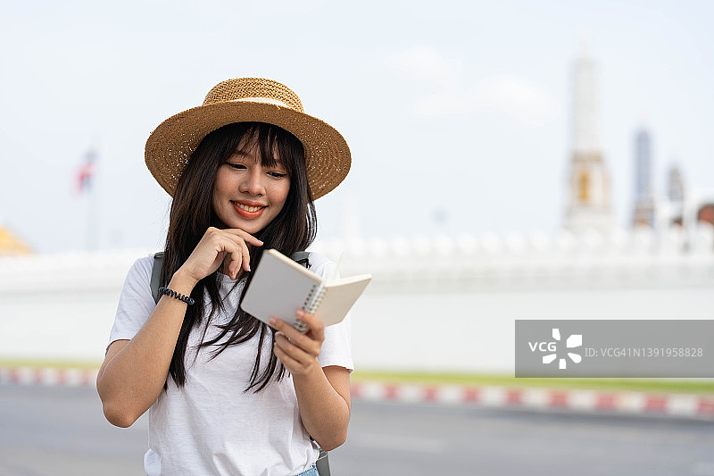 年轻女子在曼谷旅游，查看旅游指南，女游客在街上手持地图图片素材