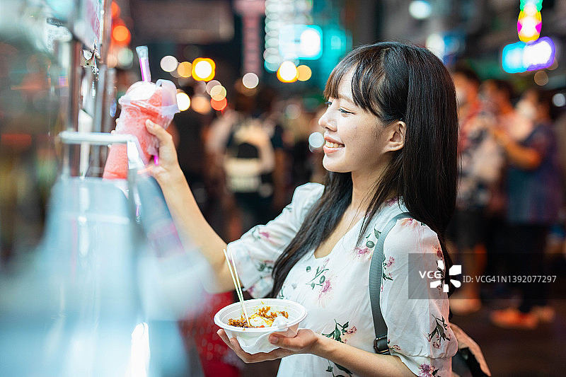 在曼谷耀华力路或中国城享受街头美食的年轻亚洲女性图片素材