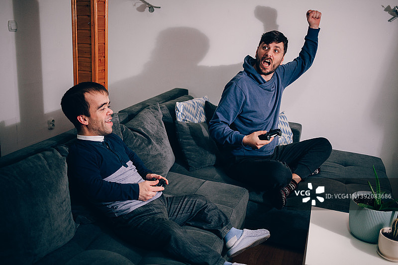 兴奋的朋友们玩PlayStation游戏机图片素材