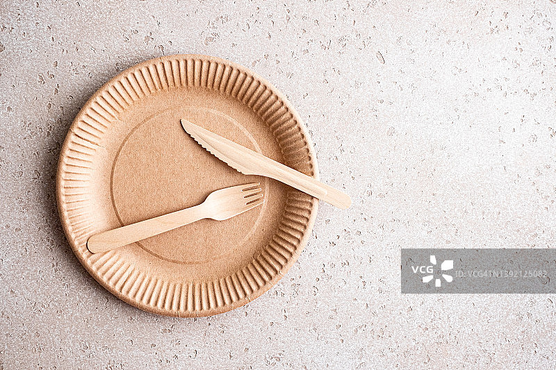 混凝土背景上的可生物降解的桦木一次性餐具和刀具，俯视图。零浪费概念。无塑料。图片素材