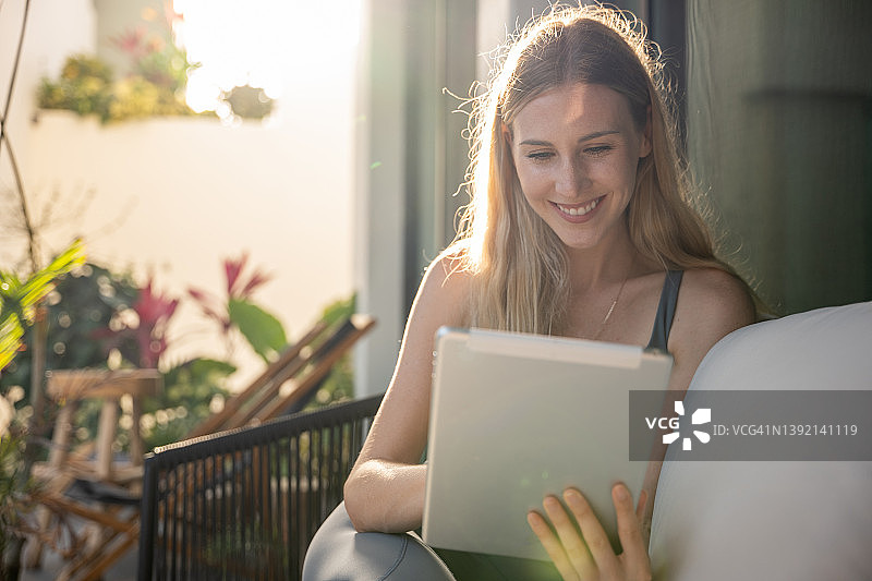 在国外使用平板电脑在线工作的年轻女人图片素材