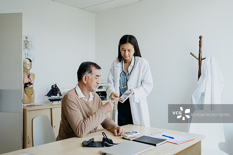 医生与患者使用平板电脑讨论医学检验结果图片素材