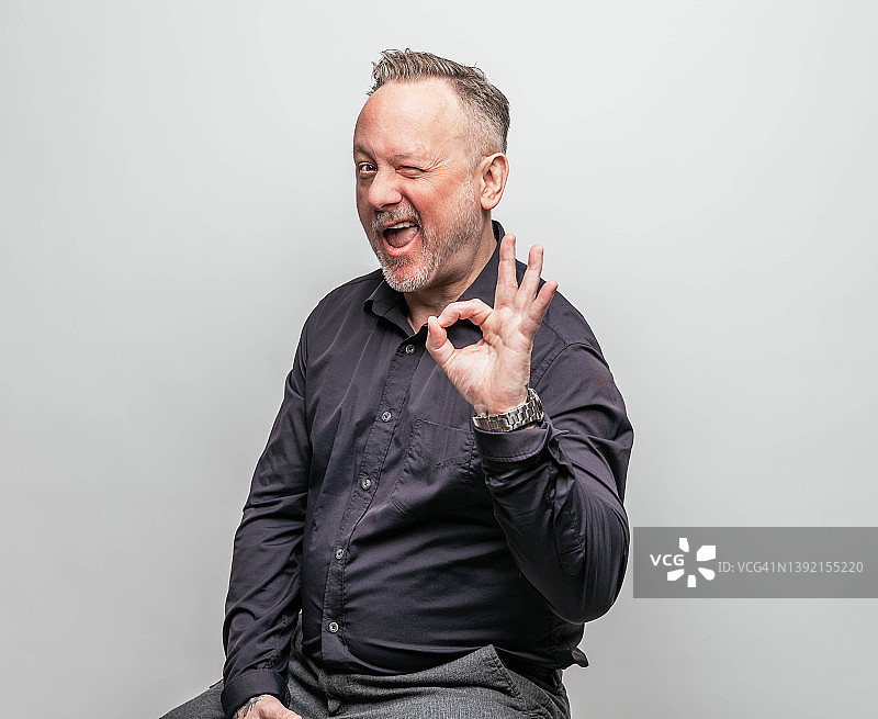 对着镜头眨眼的中年男人图片素材