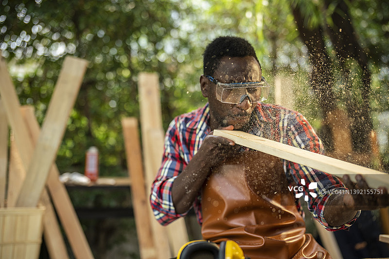 木匠吹走木板上的锯末图片素材