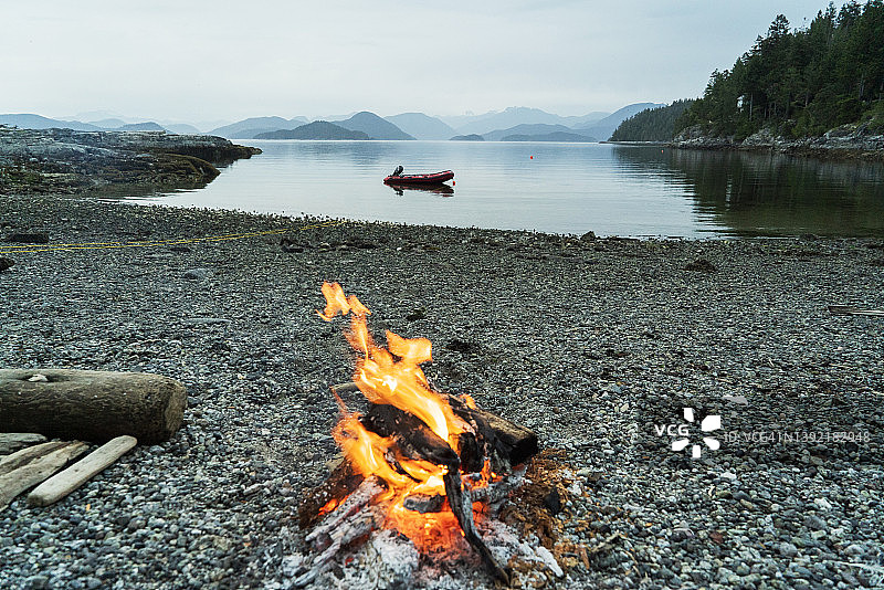 rocky 海滩上的篝火，远处是山脉图片素材