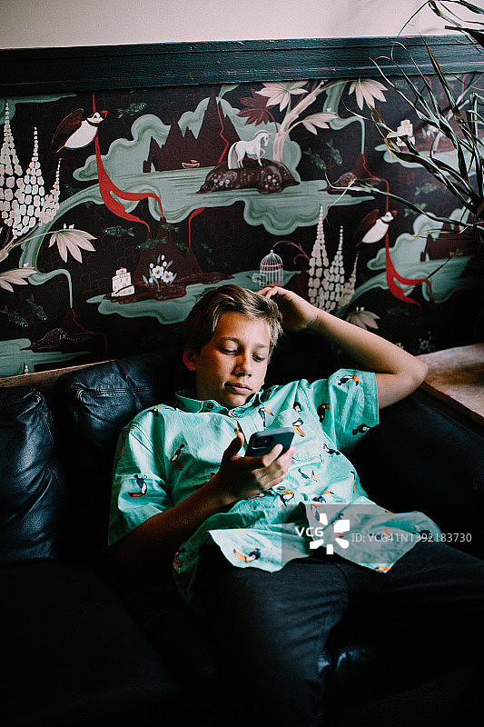 青少年在酒店大堂浏览智能手机图片素材