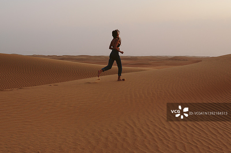 女孩在沙漠的沙滩上摆姿势图片素材