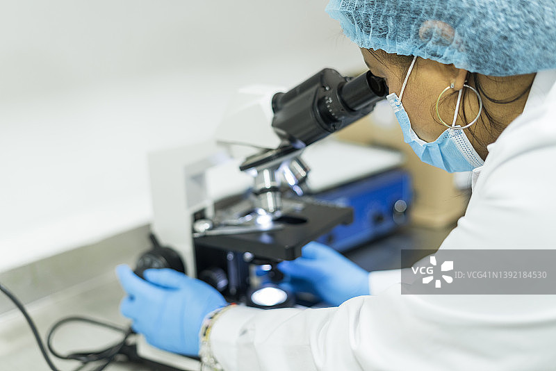女细菌学家通过先进的显微镜分析医学样本图片素材