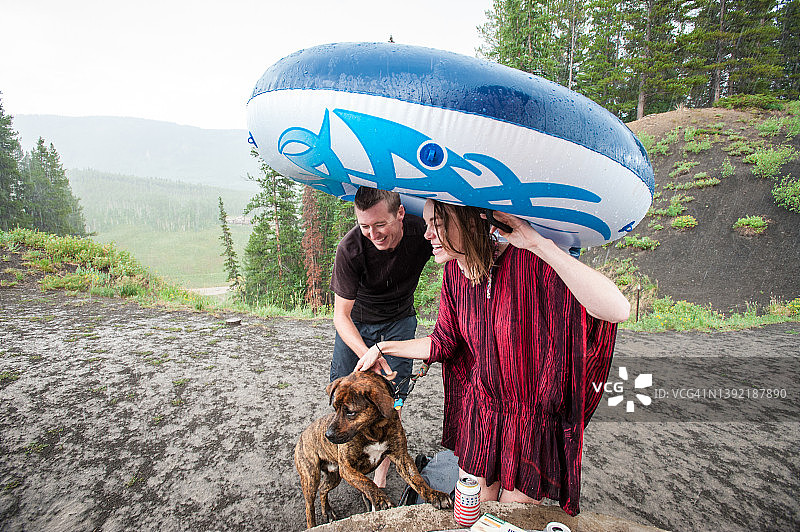 年轻夫妇和他们的狗在湖里游泳图片素材