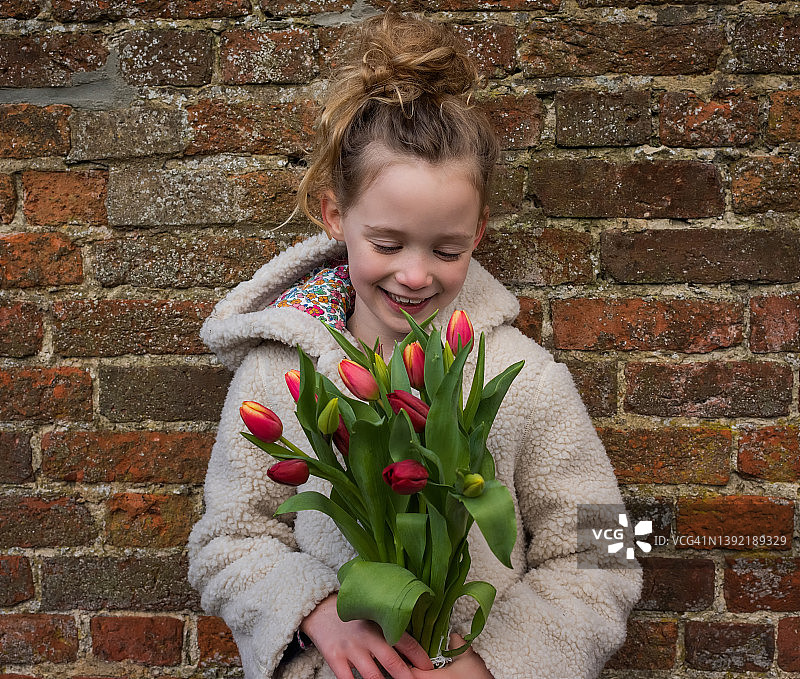 手捧鲜花微笑的年轻女孩肖像图片素材