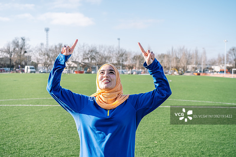 运动场上举起食指的微笑阿拉伯女性图片素材