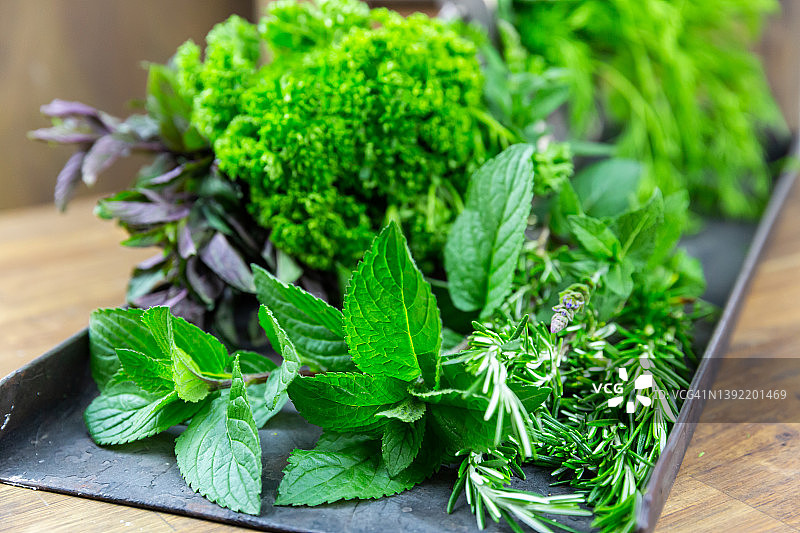托盘上摆放的什锦新鲜绿色香草图片素材