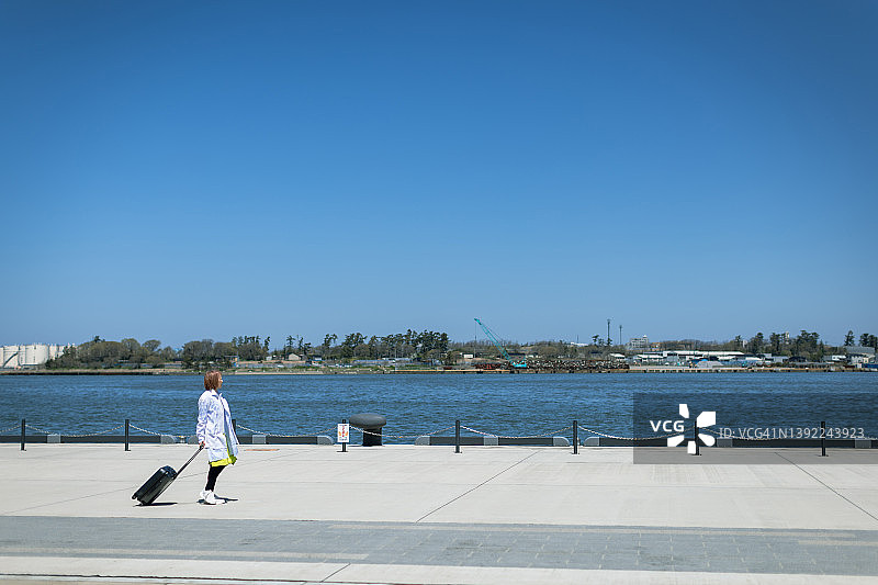 在码头航站楼携带行李旅行的女人图片素材