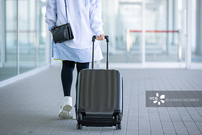 在码头航站楼携带行李旅行的女人图片素材