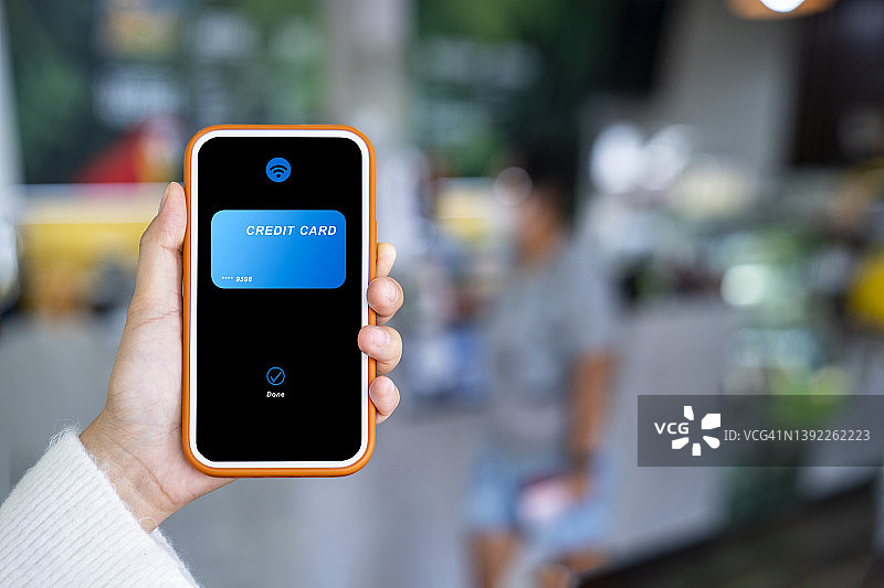 女人在商店自助收银台用手机进行非接触式支付图片素材