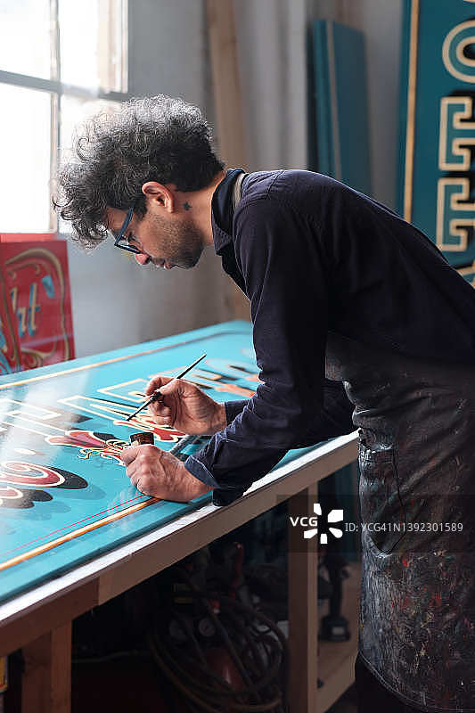 工作室里辛勤工作的招牌制作者图片素材