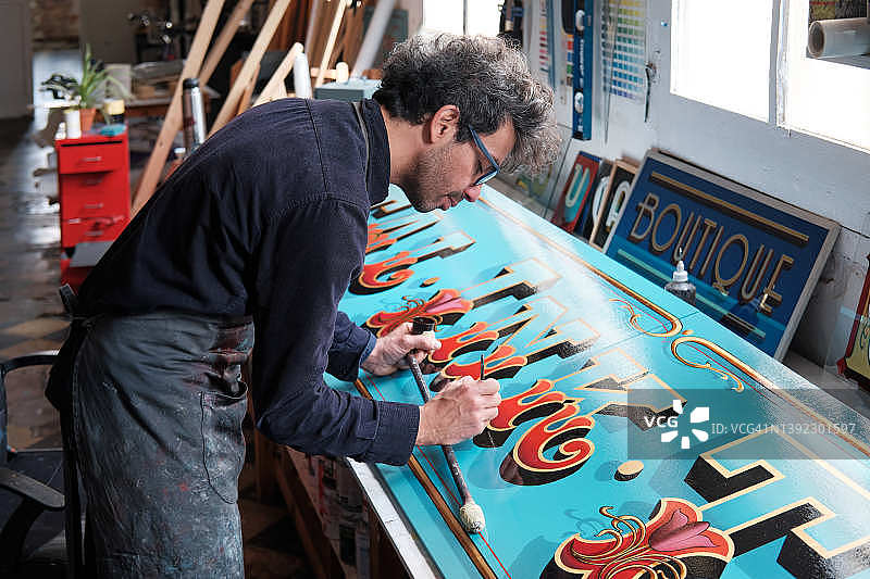 工作室里辛勤工作的招牌制作者图片素材