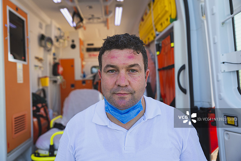 疲惫的男护理人员展示了因疫情期间整天戴口罩而造成的瘀伤图片素材