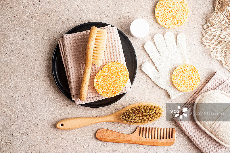 环保身体护理用品套装（木制身体刷、清洁手套、清洁海绵、精华液瓶、发刷、保湿霜）和可重复使用的网袋图片素材