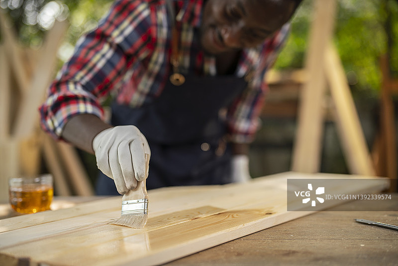 木工车间画笔在木板上油漆特写图片素材