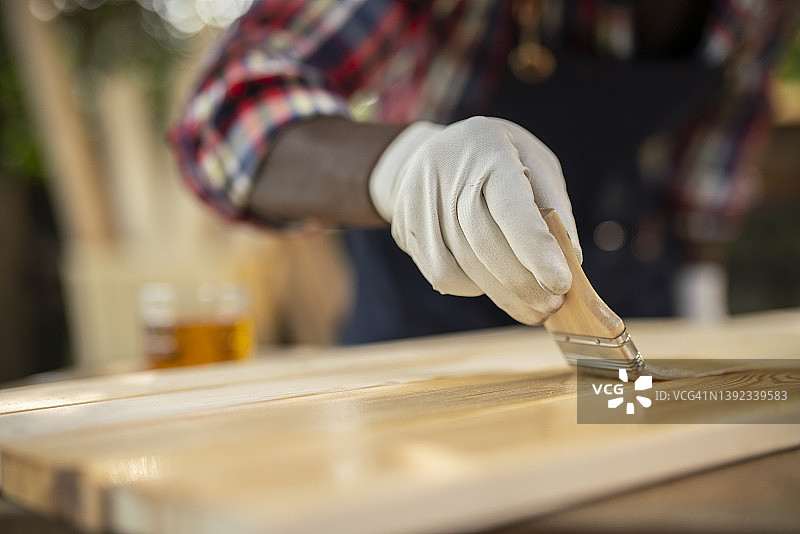 木工车间画笔在木板上油漆特写图片素材