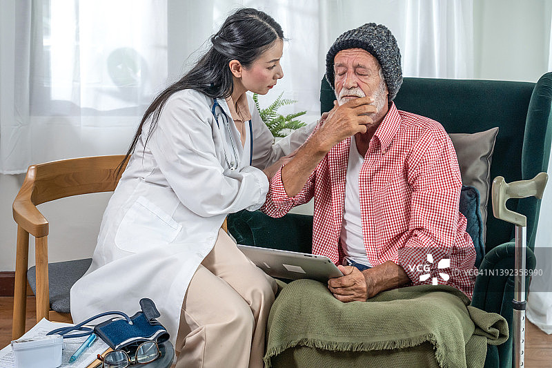 一位女医生在家里和一位坐轮椅的老人谈话。图片素材