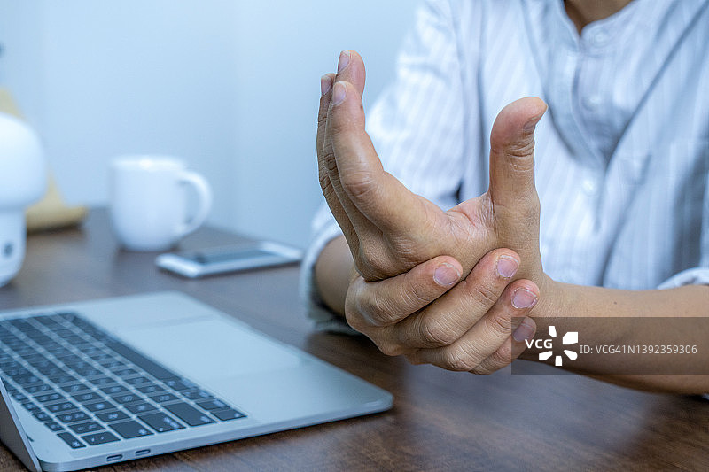 使用电脑导致手腕疼痛的职业女性图片素材