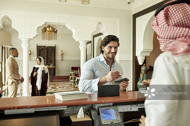 利雅得豪华酒店的男客人办理退房手续图片素材