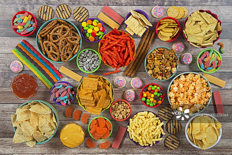 木质背景上的咸味和甜味小吃图片素材
