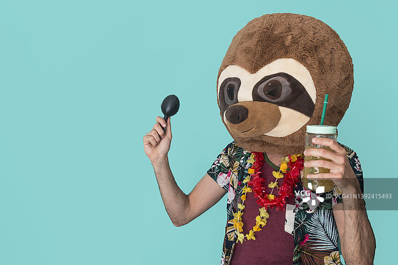快乐的男人戴着动物面具，穿着夏装在蓝色背景前跳舞图片素材