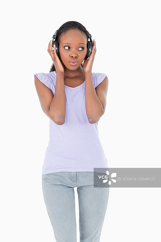 特写：在白色背景下听音乐的女人图片素材