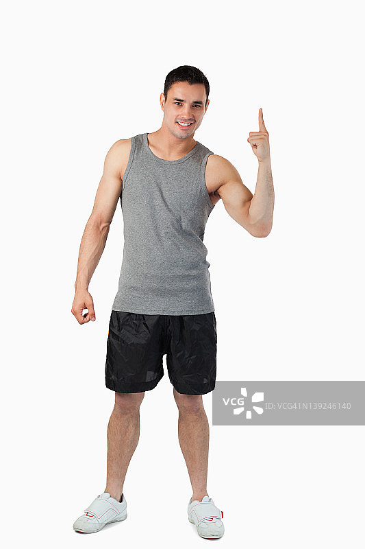 身穿浅色运动服向上指的年轻男人图片素材
