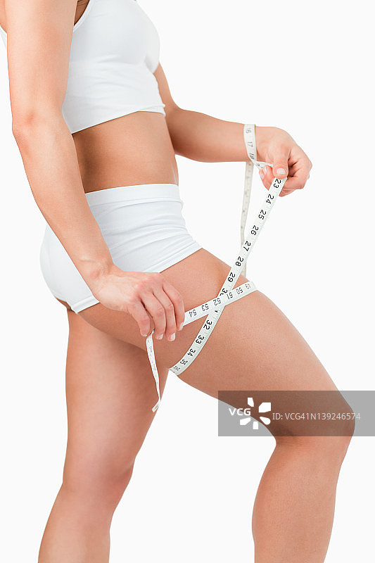测量大腿的健壮女子肖像图片素材