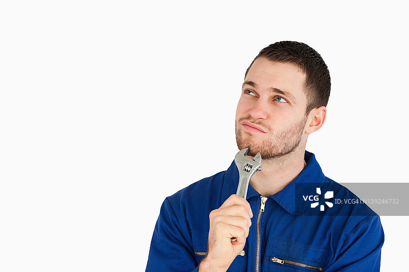 穿着工作服思考的年轻机械师图片素材