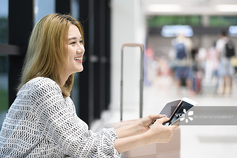 在机场候机区休息的微笑青年女人像图片素材