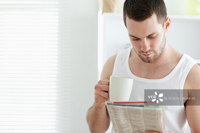 微笑的男人一边喝咖啡一边看新闻图片素材