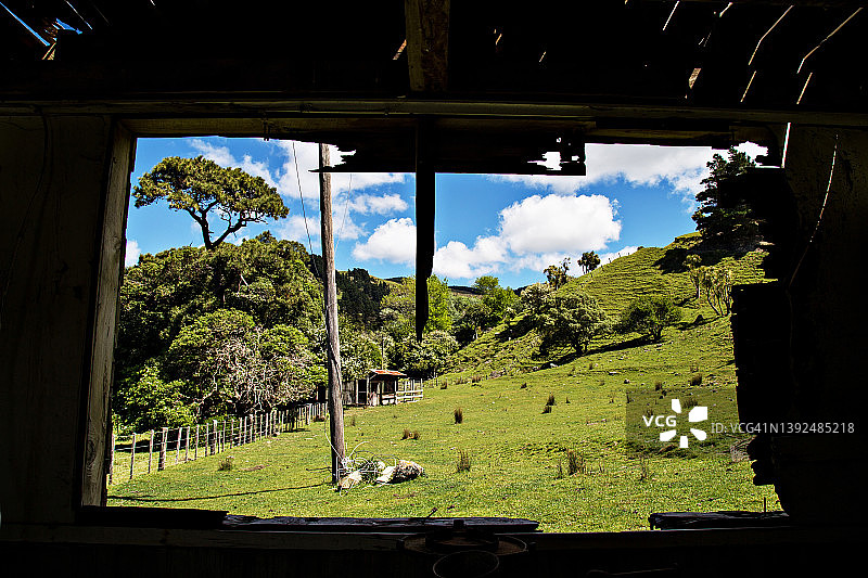 老旧风化谷仓窗框中的绿色牧场景观，怀拉拉帕乡村图片素材